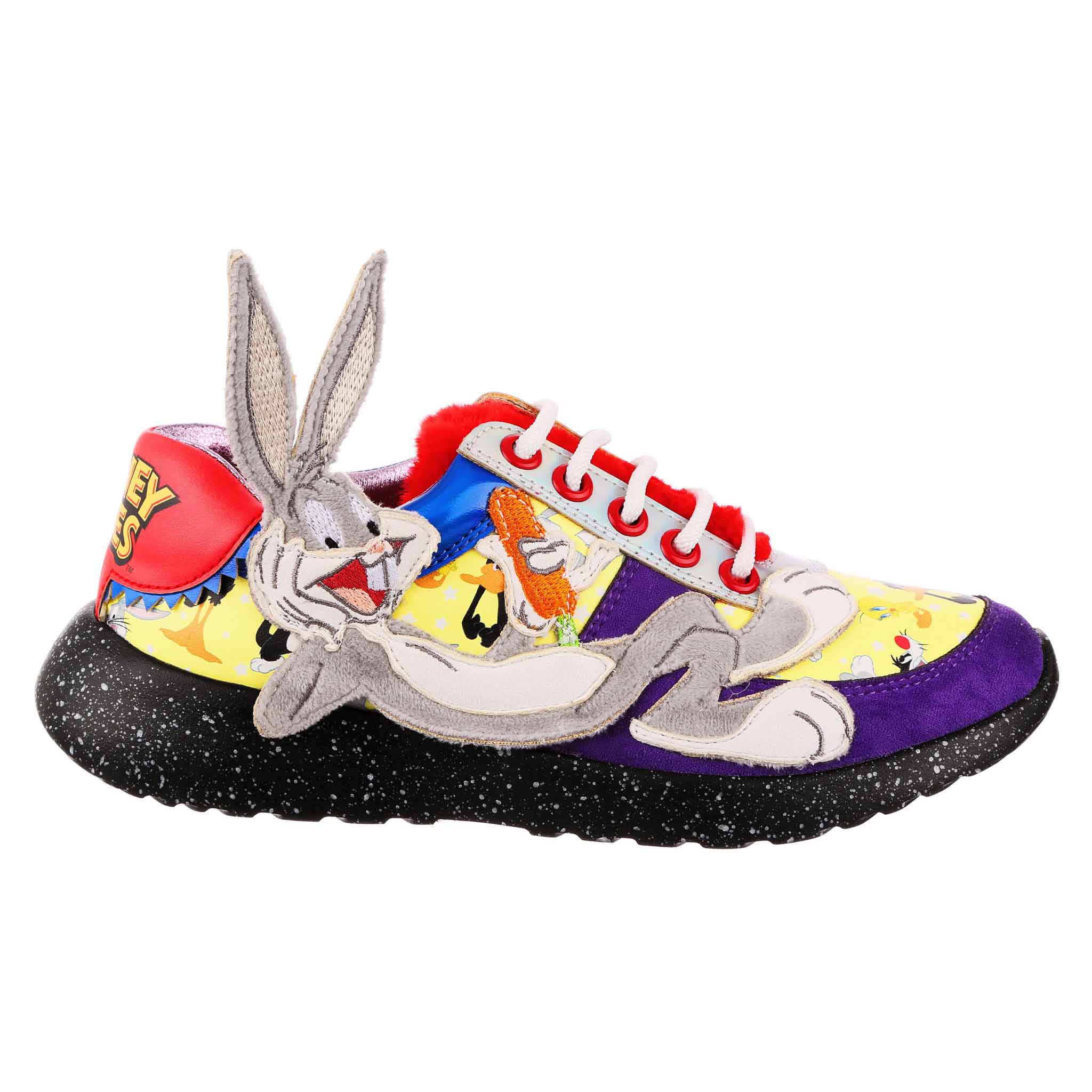 Lace-up trainers with purple suedette fabric, contrasted with yellow repeat pattern of popular Looney Tunes characters. A furry applique of Bugs Bunny lounging along the outside of the shoe, with his face and ears coming off of the shoe. A fluffy red tongue is matched to the logo printed on the heel.